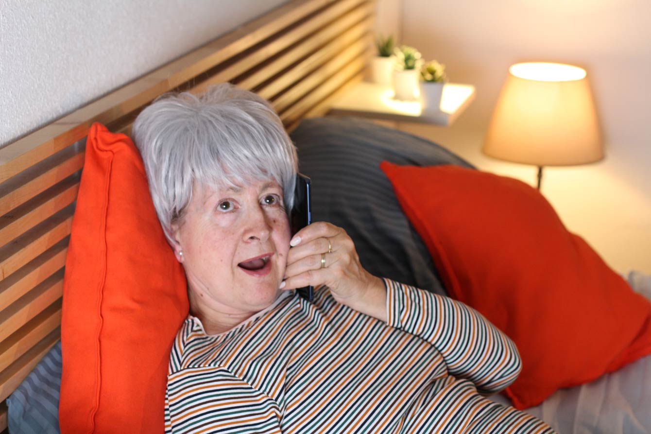 senior lady in her bedroom chatting on the phone