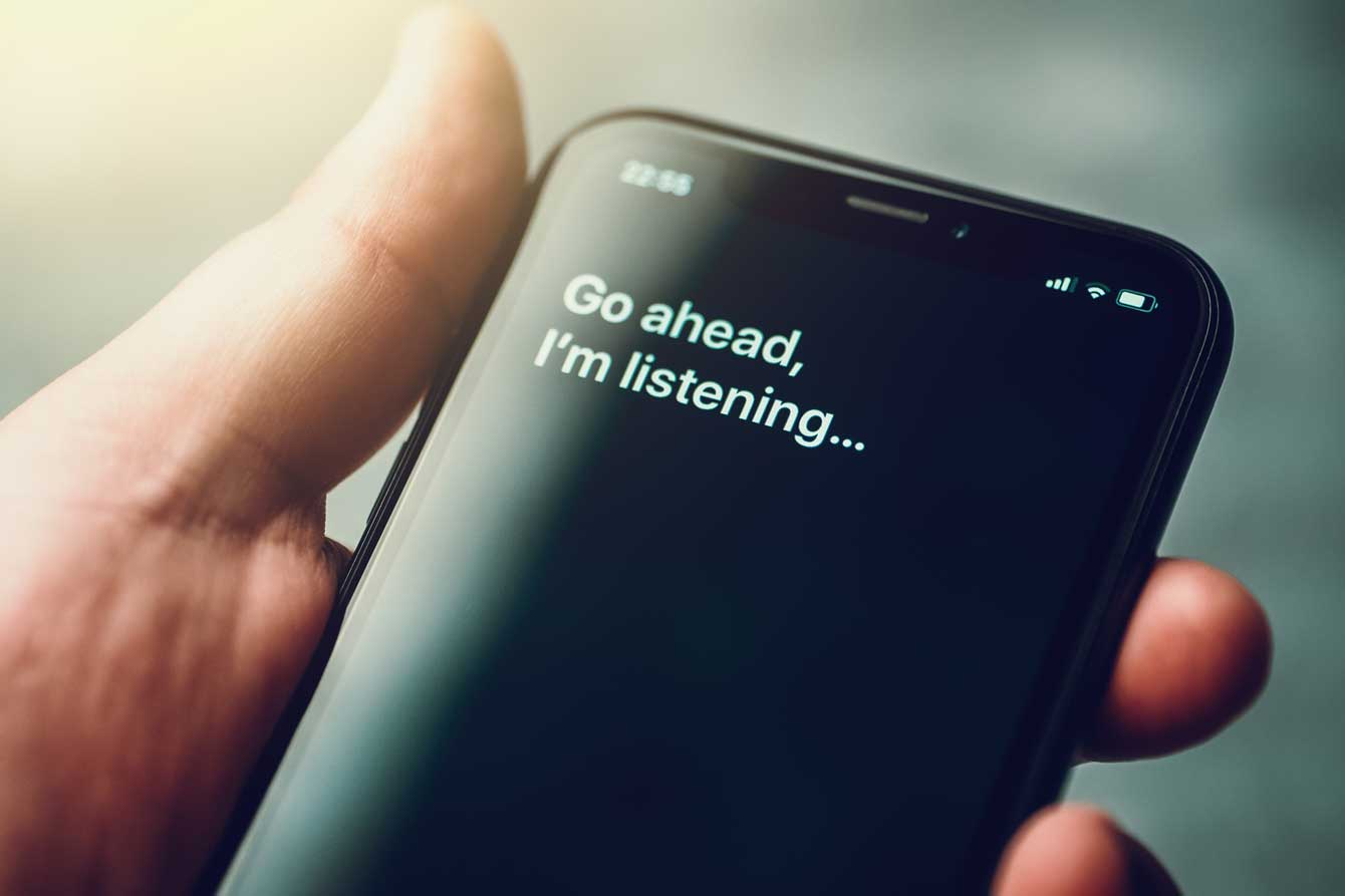 Voice activated digital assistance on smartphone with text on screen that reads go ahead i'm listening