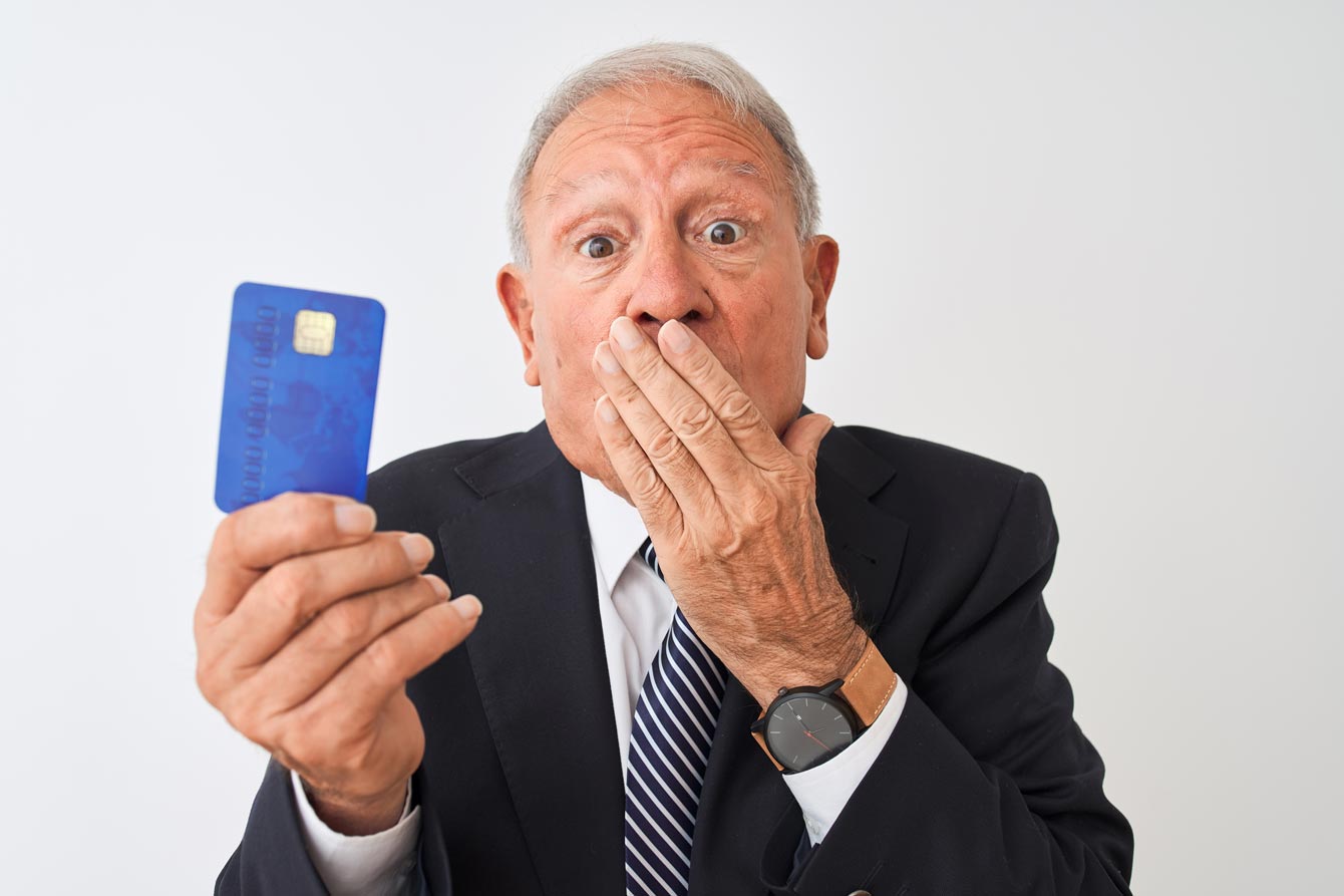 Senior grey-haired businessman holding credit card