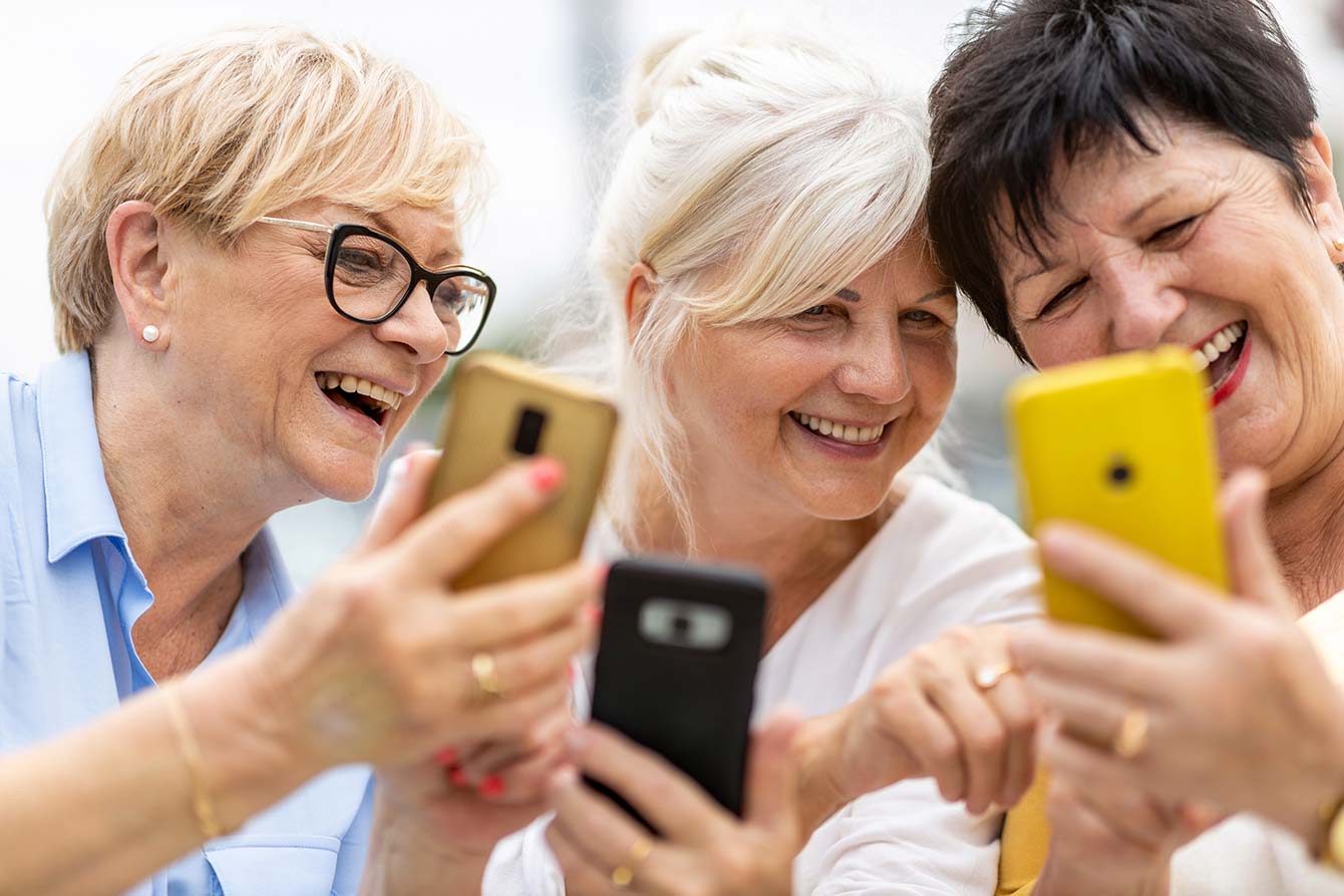 Group of senior women using smart phones together