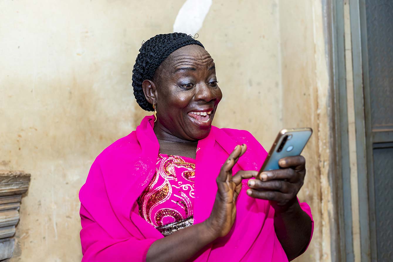 Happy senior black lady using smart phone