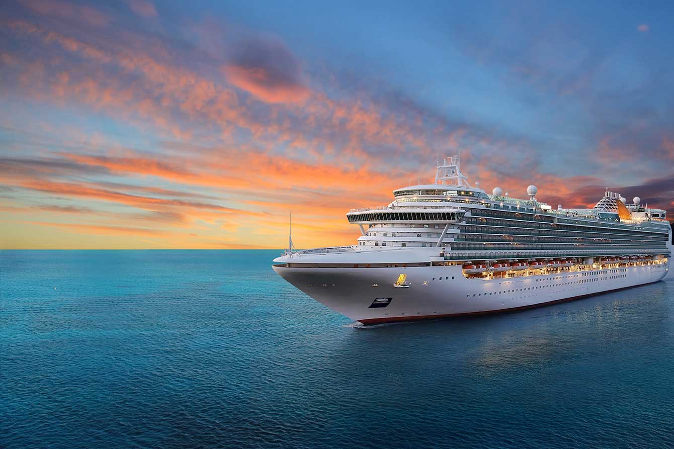 Luxury cruise ship sailing to port at sunrise