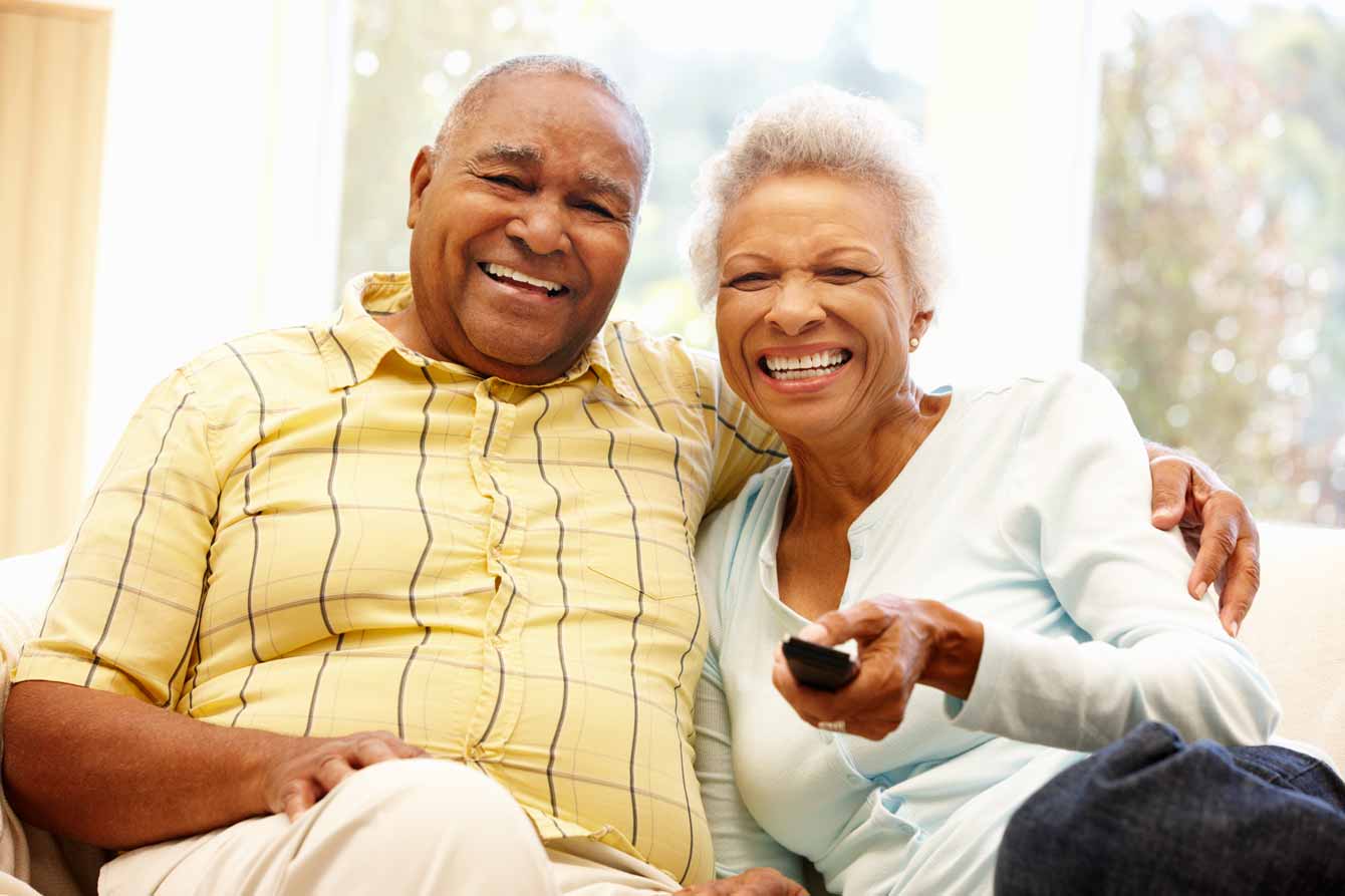 Senior black couple watching tv together