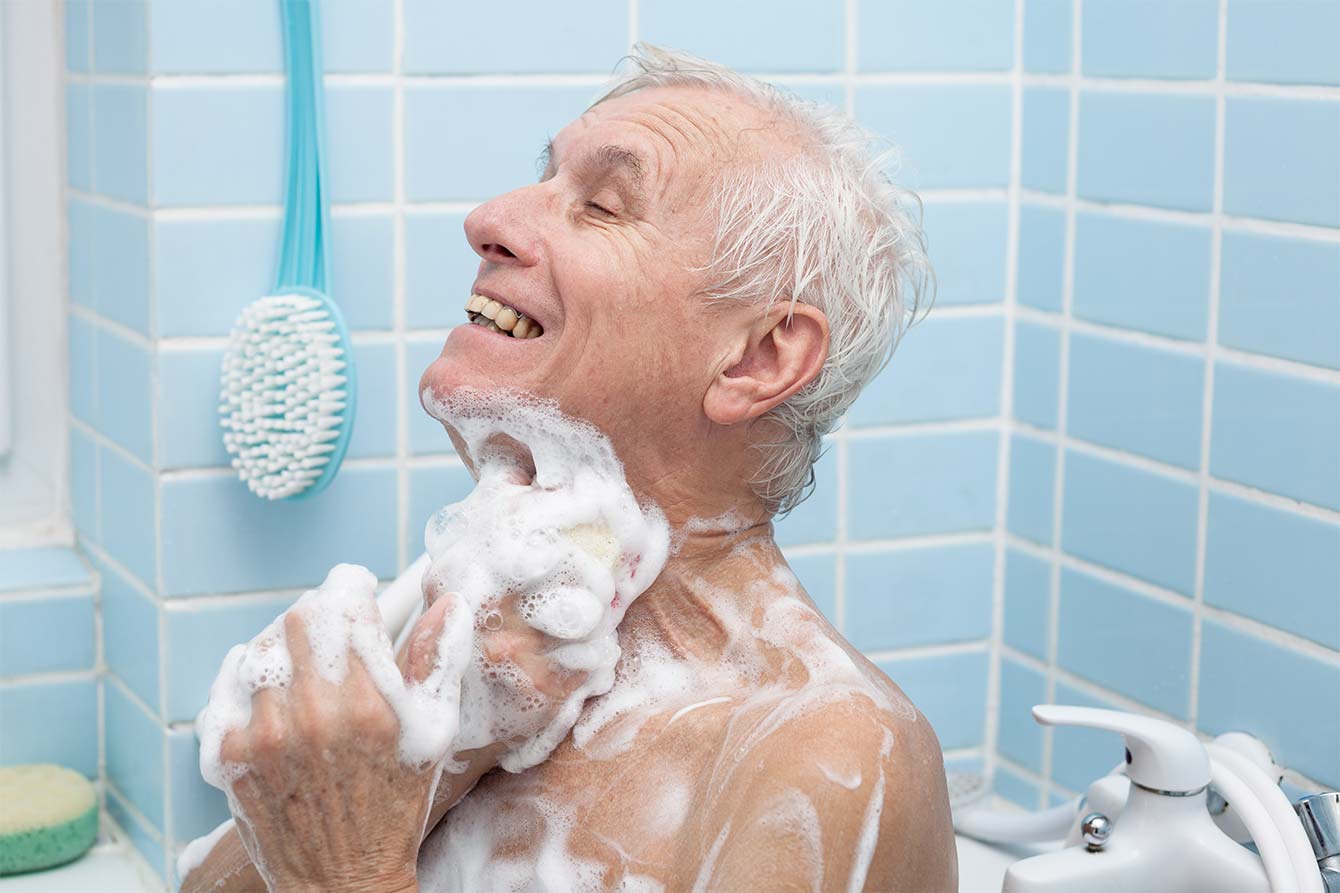 Senior man bathing with lots of foamy soap