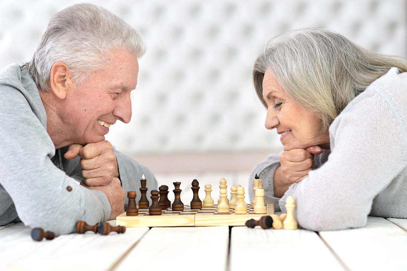 Happy senior couple playing chess