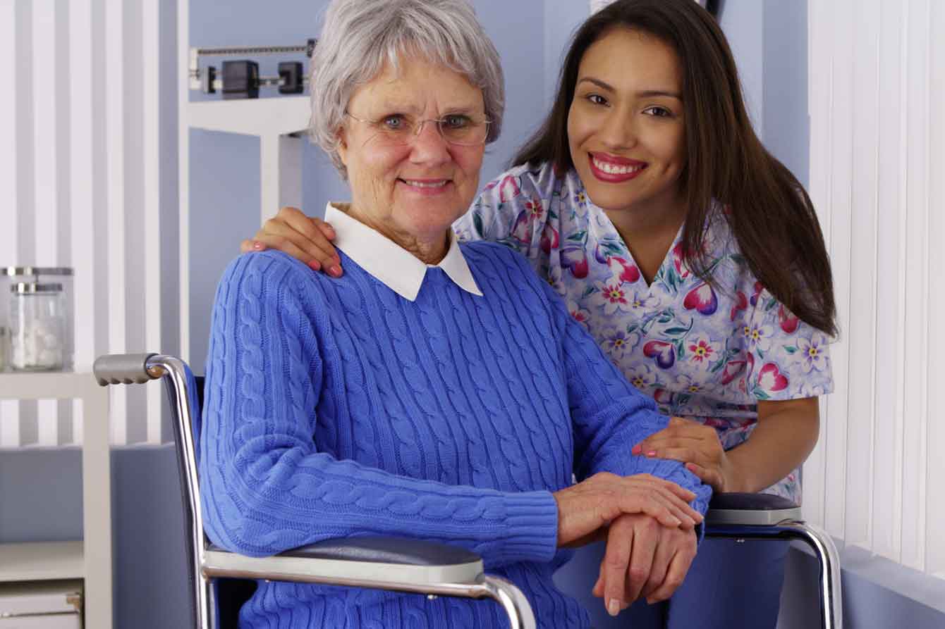 Senior woman in wheelchair with latina caregiver
