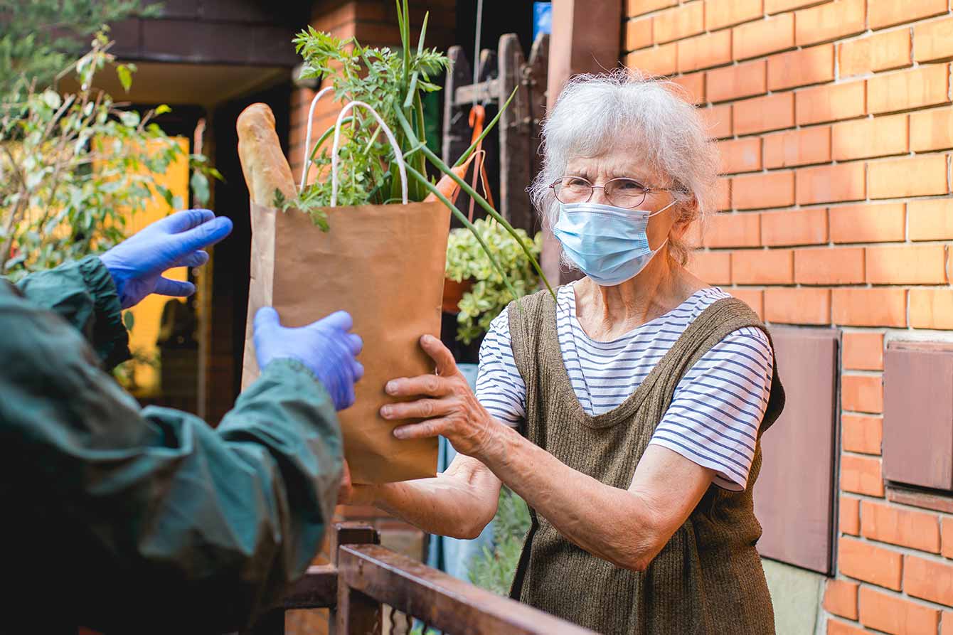 Older woman with tooth pain informs a dentist