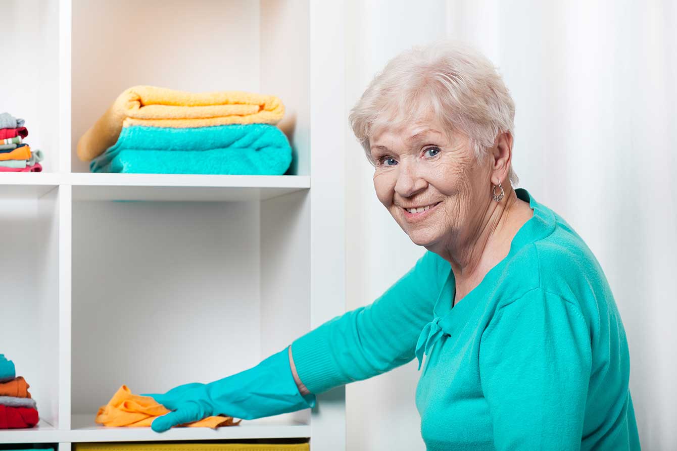 Senior woman cleaning her house