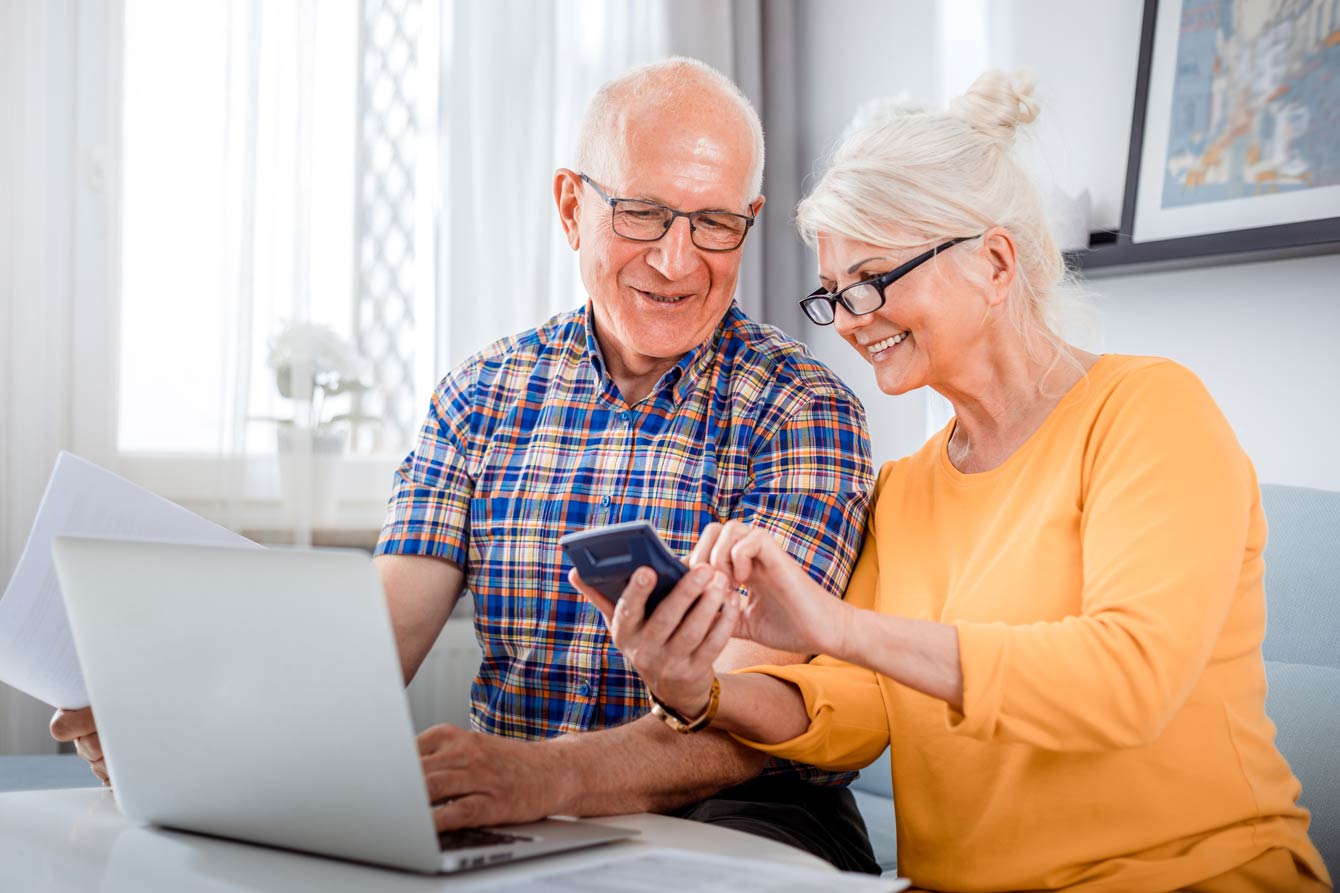 senior couple checking their savings using their laptop and calculator