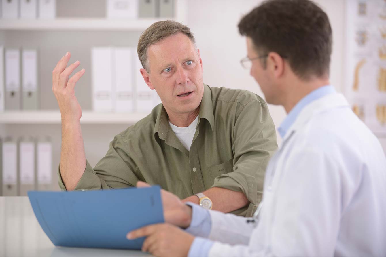 Doctor speaks with a frustrated male patient