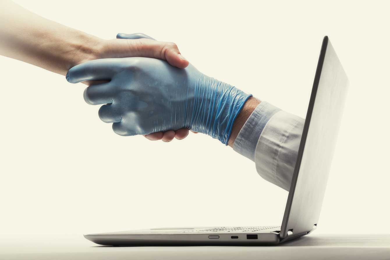 A gloved doctor's hand reaches out from a laptop screen and shakes hands with a patient