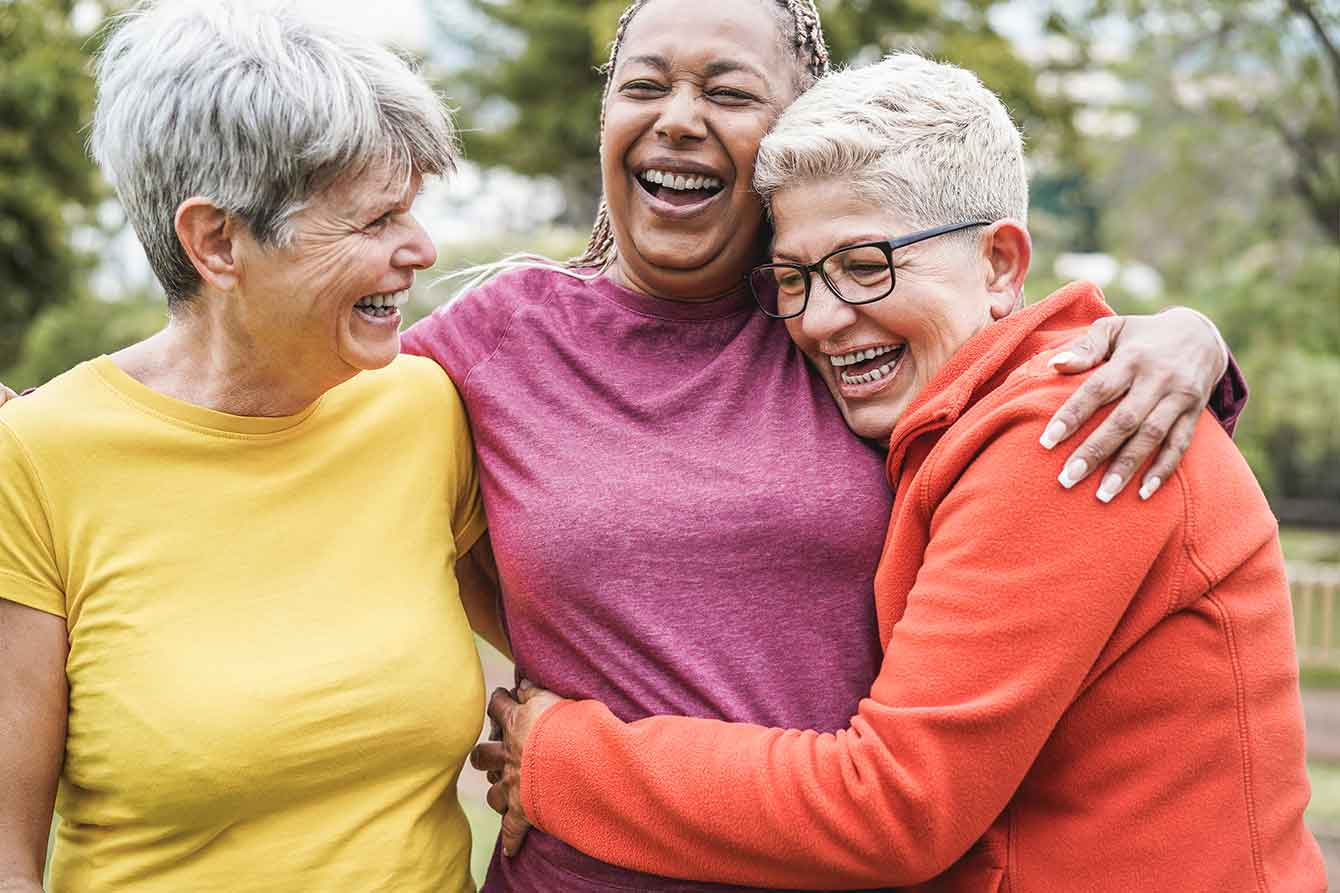 Group of older women embrace, happy