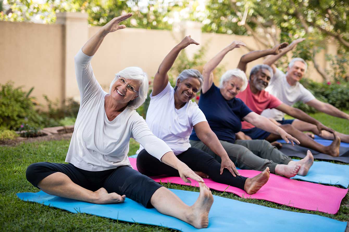 Portrait of smiling senior friends exercising in the park