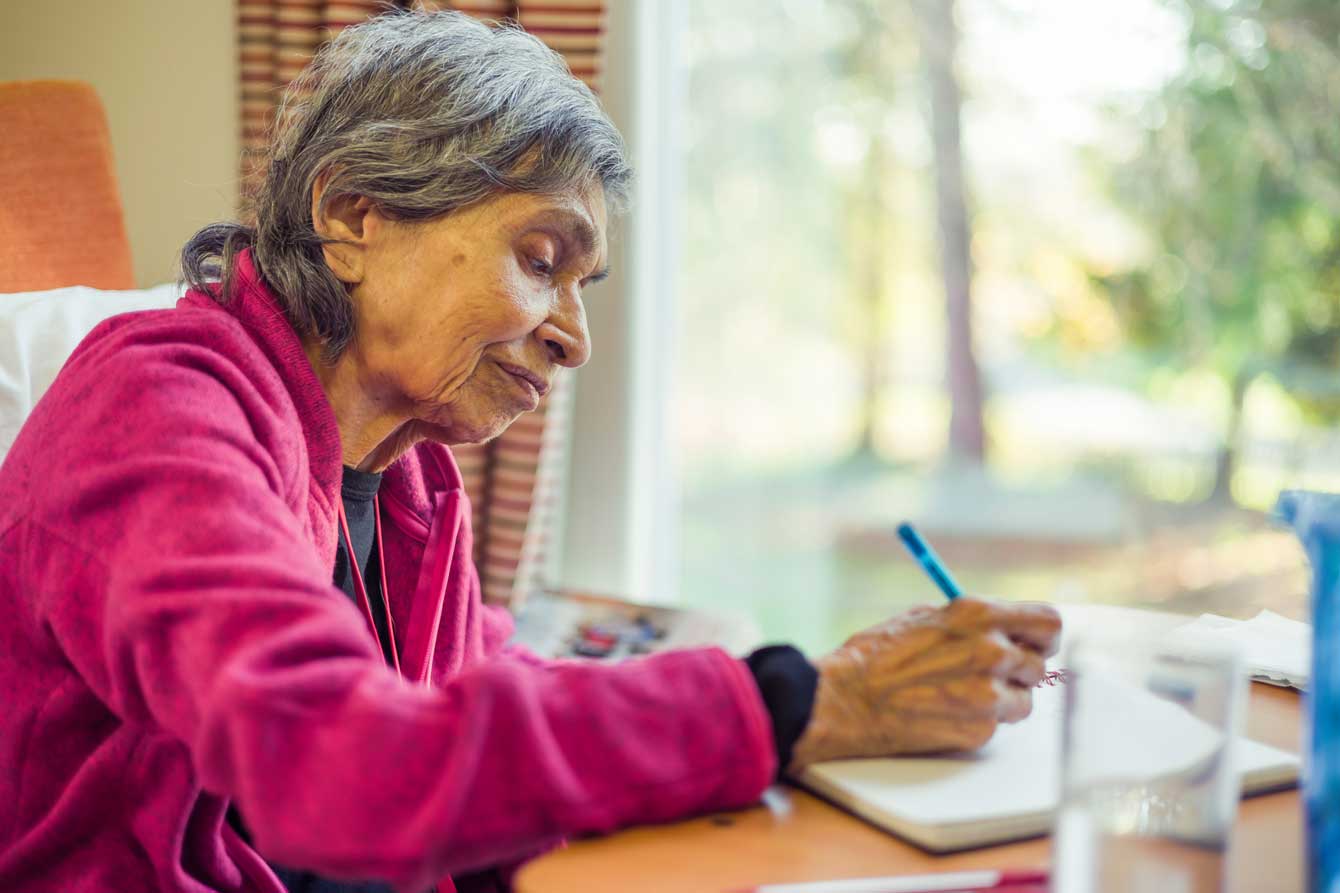 An older woman prays holding rosary beads