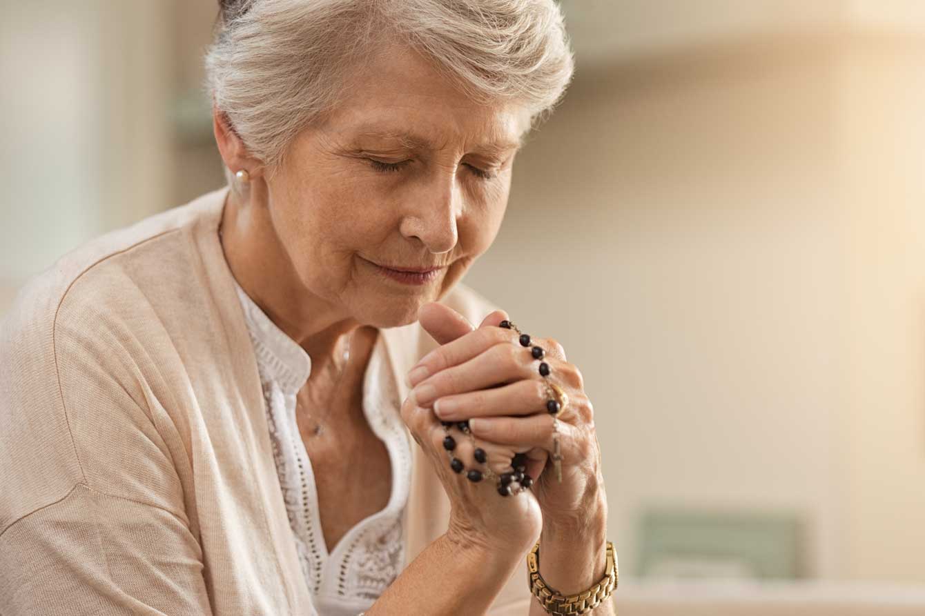 An older woman writes in a notebook
