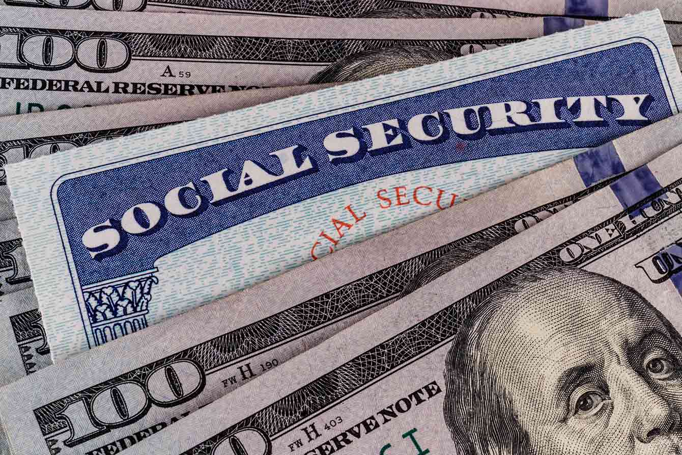Social Security card and a bed of money representing the high cost of living on a fixed income