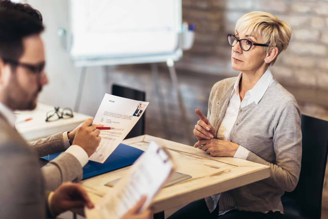 senior job seeker confidently talks to her interviewers