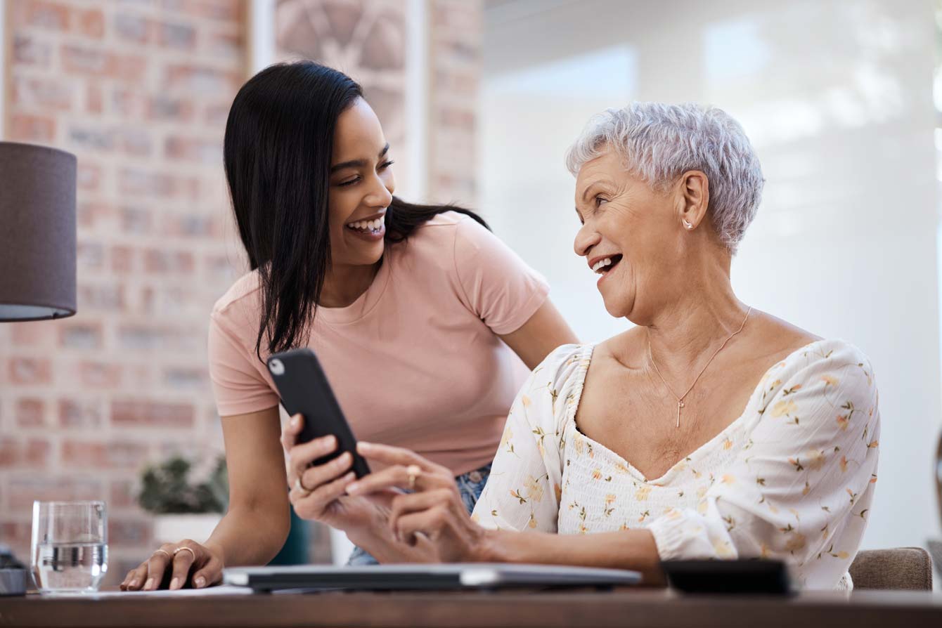 elderly mother with daughter having a good time while learning about her new phone