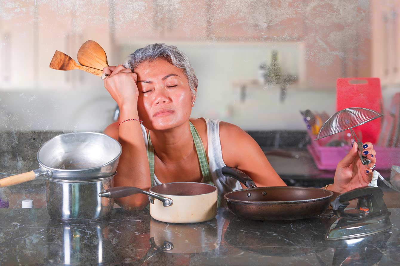 Stressed asian senior woman having issues cooking