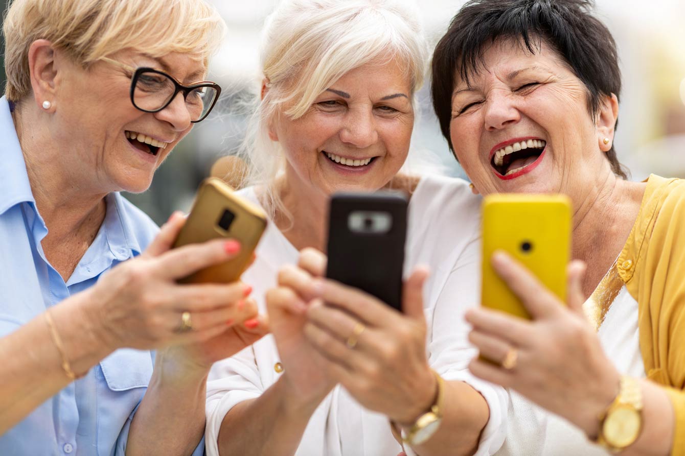 3 senior women using their phones together