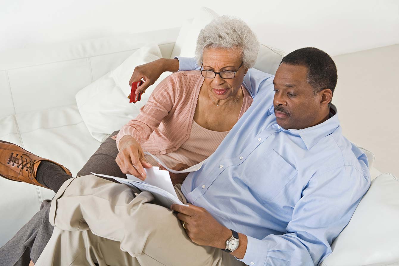 African american senior couple looking at their bills