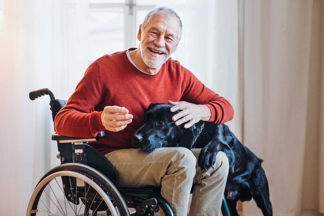 senior disabled veteran in his home with his companion dog