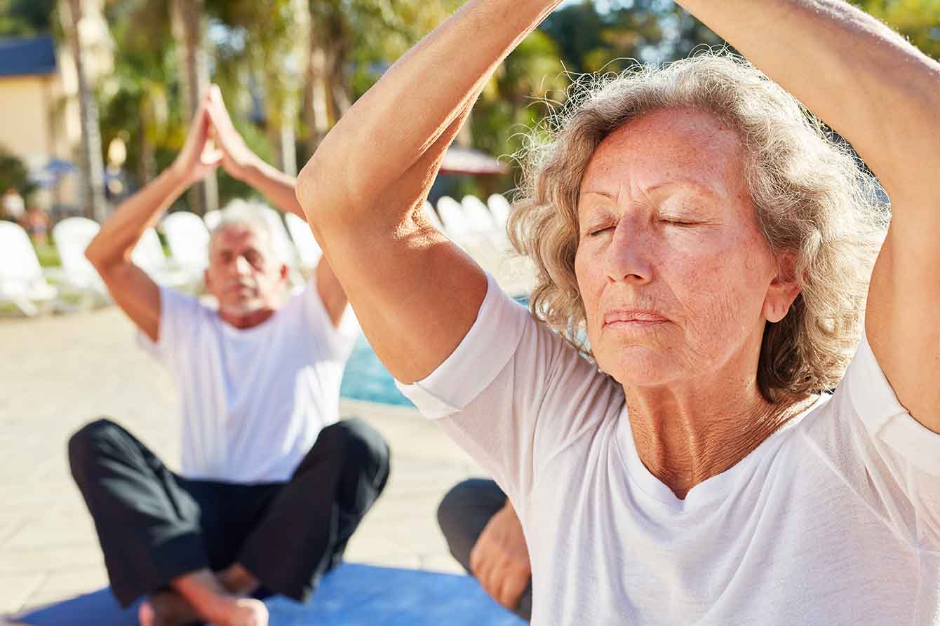 Older woman meditates in a group