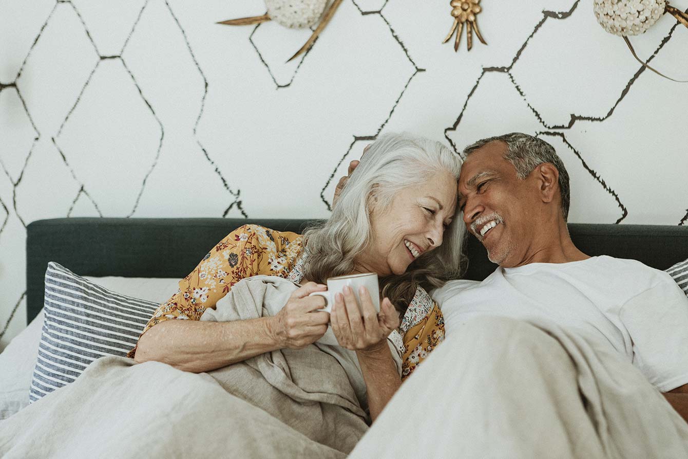Cute senior couple laughing in bed together