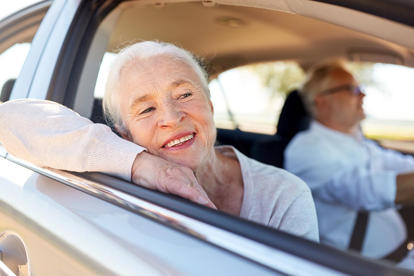 Happy senior couple driving in a car