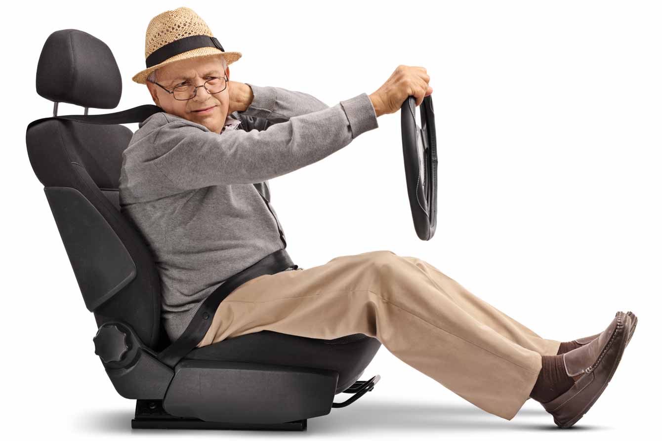 An older man sits in a car seat and holds a wheel with a white background