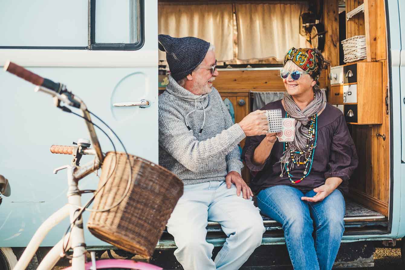 Senior couple drink coffee in their mobile home