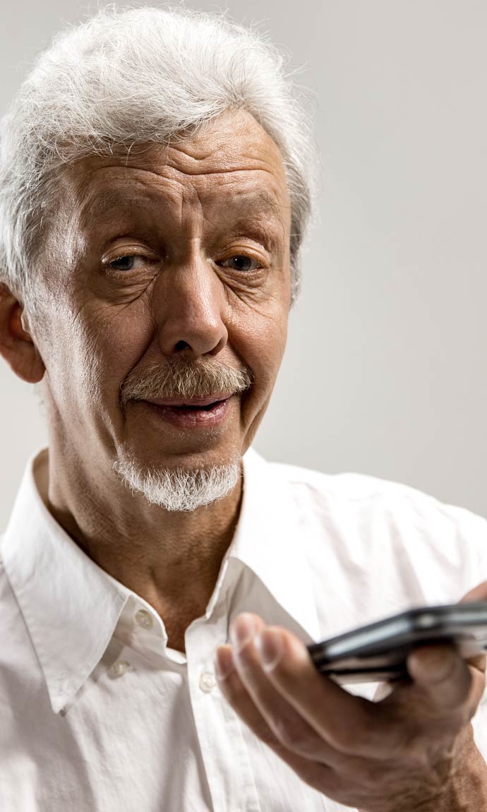 senior man holding smartphone using voice control