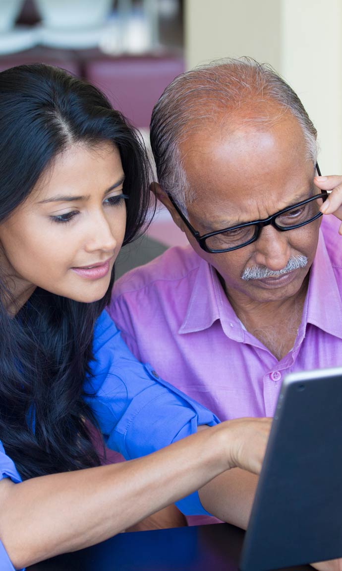 daughter teaching senior father the accessibility features of his tablet