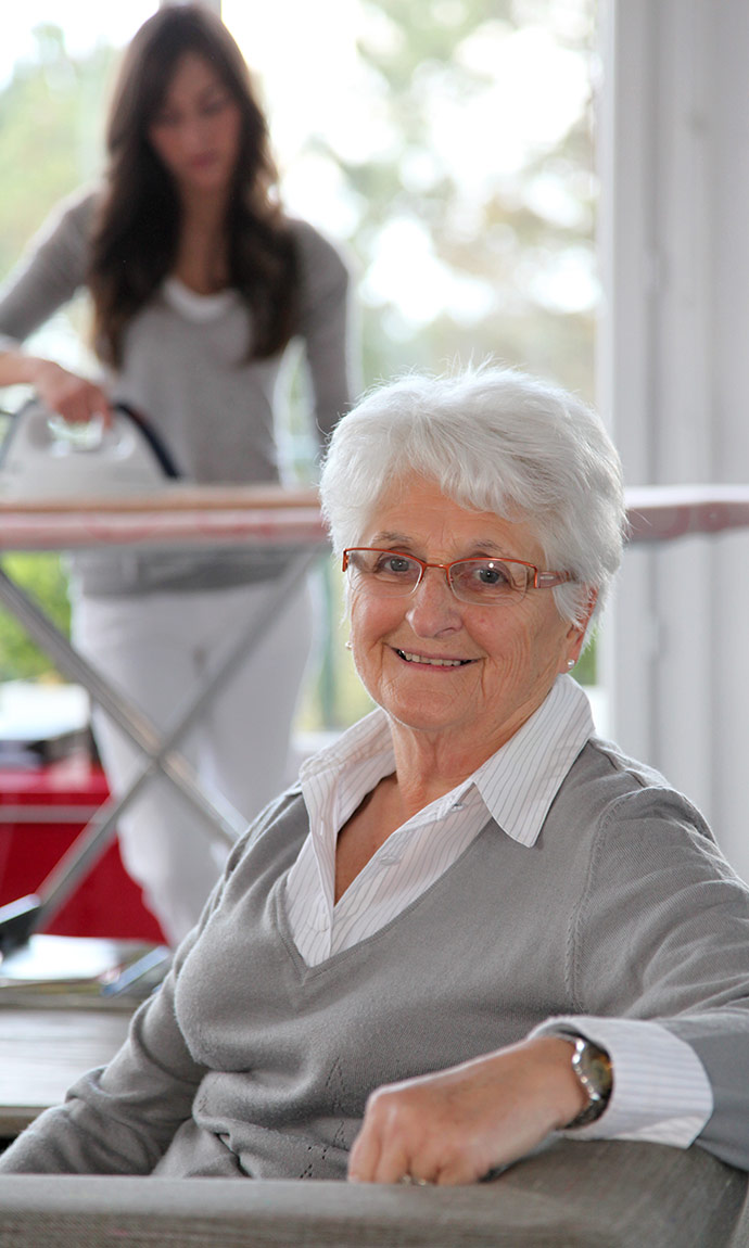 senior with home care worker ironing