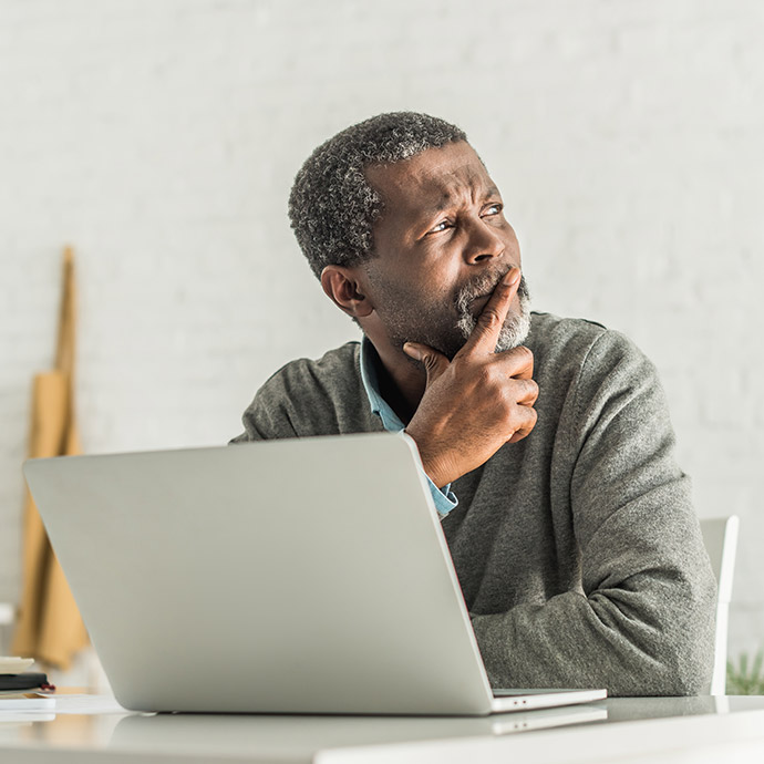 senior on laptop thinking