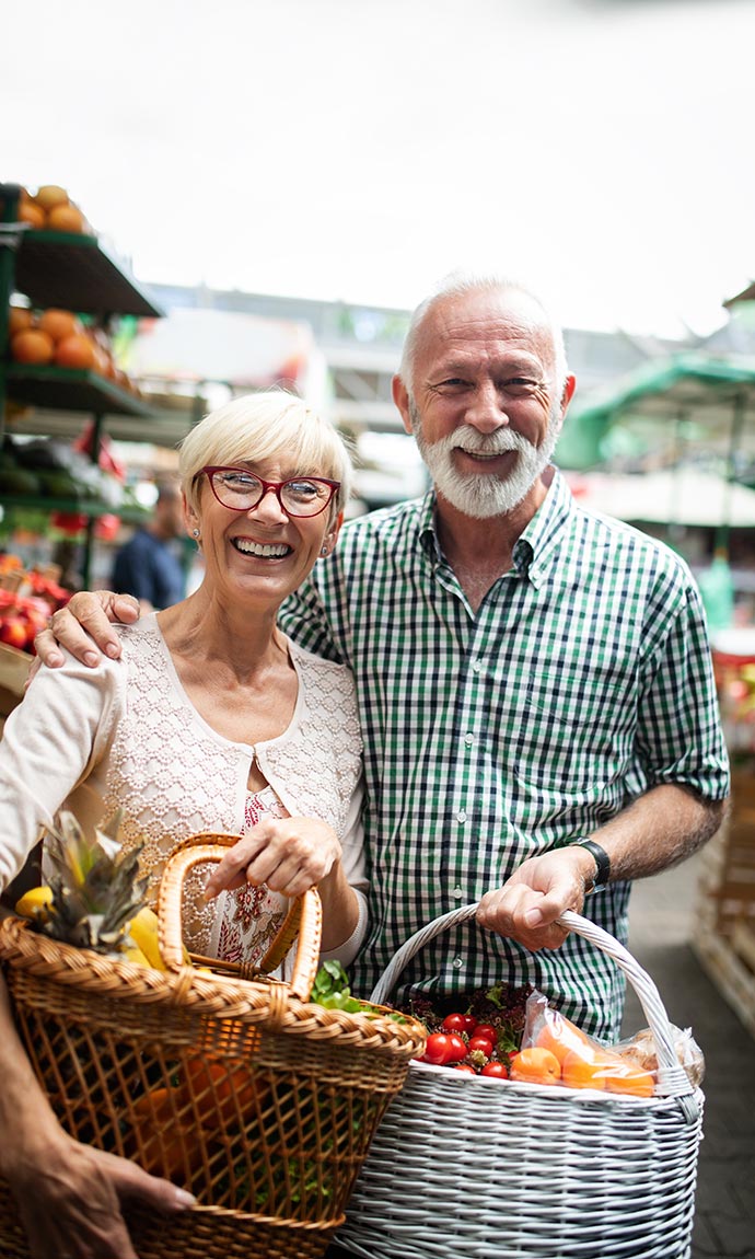 senior couple with vegetables baskets