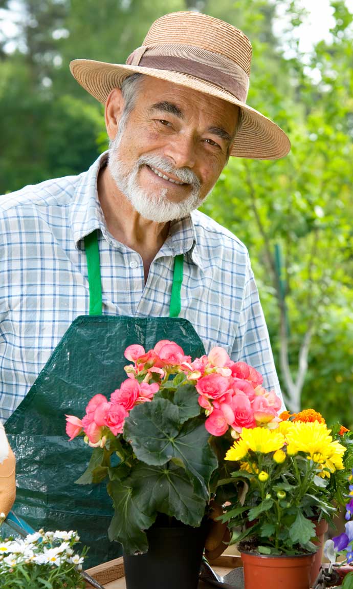 senior man proudly shows his flowers in the garden