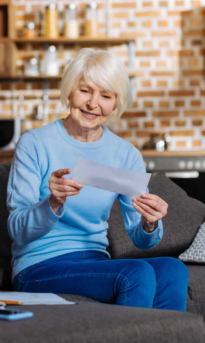 senior lady looks joyful with her pension cheque