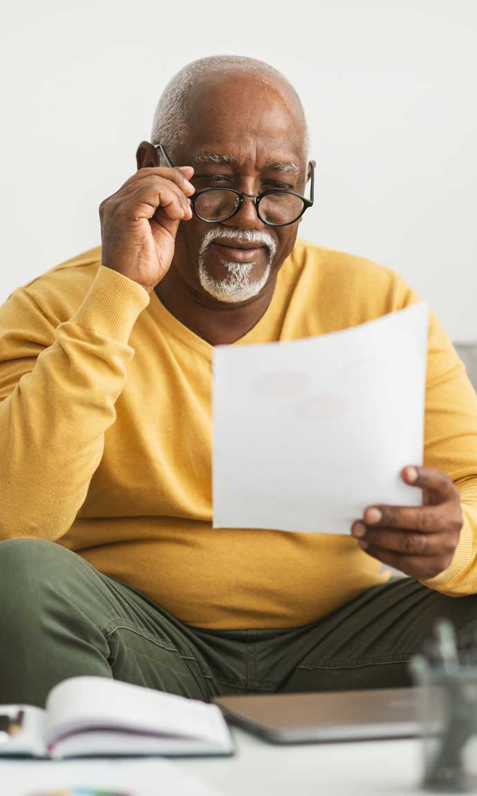 elderly male reads his documents for filing taxes