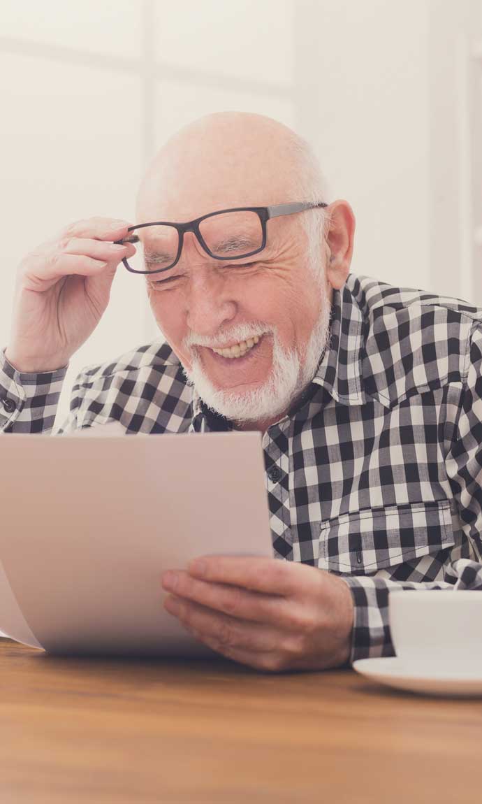 senior man reading tons of paperwork for his taxes