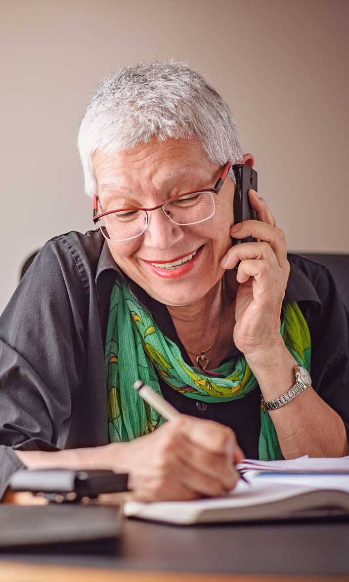 senior lady fixing her calendar while chatting on the phone