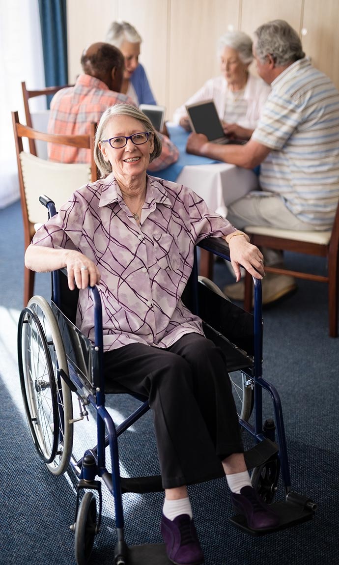senior in wheel chair in group room