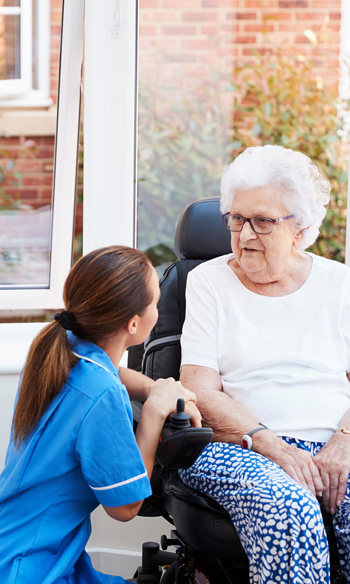 senior in mobility chair with nurse