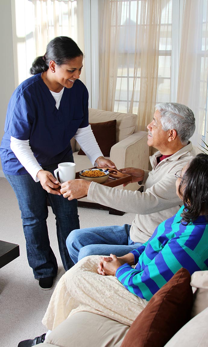 home care worker serving seniors breakfast