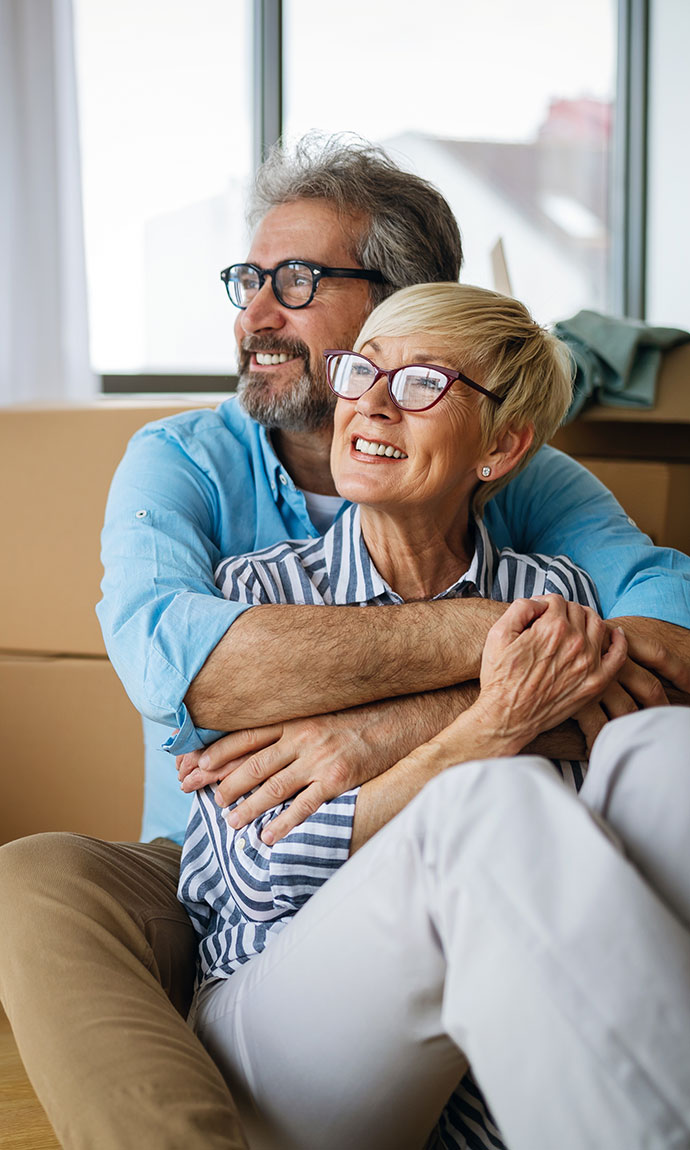 happy senior couple in house with boxes