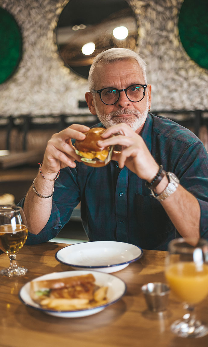 senior man holding a burger